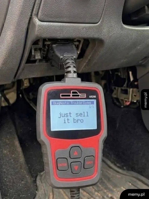 Skaner diagnostyczny OBD podłączony do samochodu z napisem just sell it bro na ekranie