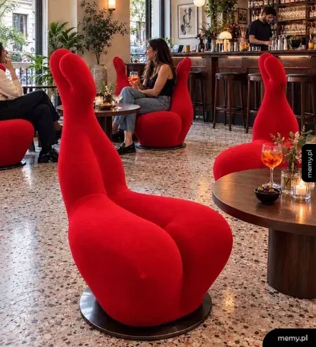 Czerwone fotele w restauracji o nietypowym kształcie przypominającym pośladki.