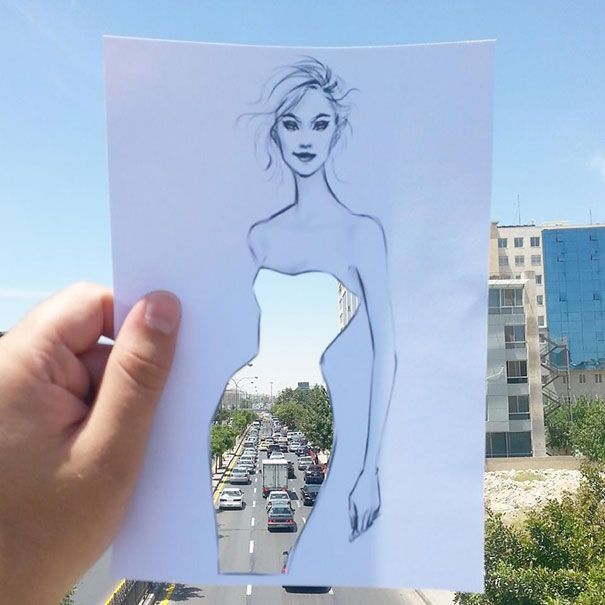 Ilustrator mody wykańcza swoje powycinane sukienki chmurami oraz budynkami